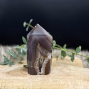 Agaat punt met kristallen op een houten tafel, Agaat punt met glinsterende kristallen, Agaat punt met warme kleuren en glinstering