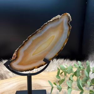 Prachtige agaatschijf op standaard als decoratie, Unieke agaatschijf met natuurlijke patronen en kleuren, Spirituele werking van agaatschijf – balans en bescherming, Agaatschijf reinigen met maanlicht en salie, Agaatschijf stijlvol gepresenteerd in een standaard, Agaatschijf op standaard