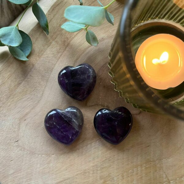 Amethist Hart op houten tafel met kaars, Amethist Hart met zijn diep paarse kleur en glinstering