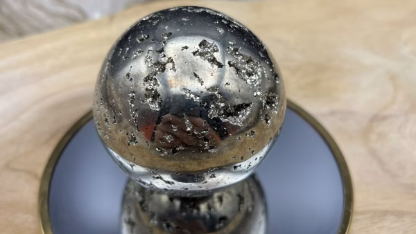 Glanzende pyriet bol met goudkleurige kristallen, Pyriet bol op standaard – een krachtig en stijlvol decoratiestuk, Close-up van een pyriet bol met natuurlijke kristalstructuren, Fotot voor de mijn account pagina