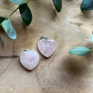 Glanzend Rozenkwarts hartje met een zachte roze tint, symbool van liefde en harmonie, Rozenkwarts hartje op een houten ondergrond, straalt rust en positieve energie uit, Klein Rozenkwarts hartje in een handpalm, perfect als betekenisvol cadeau, Rozenkwarts Hartje, Rozenkwarts hart hanger voor aan een ketting, Edelsteen hanger in hartvorm
