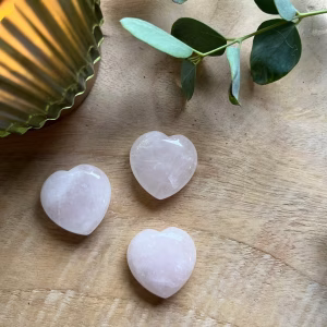 Glanzend Rozenkwarts hartje met een zachte roze tint, symbool van liefde en harmonie, Rozenkwarts hartje op een houten ondergrond, straalt rust en positieve energie uit, Klein Rozenkwarts hartje in een handpalm, perfect als betekenisvol cadeau, Rozenkwarts Hartje