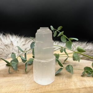 Seleniet toren 10 cm op een houten tafel met kaarsen en edelstenen, Glanzende seleniet toren in een spirituele meditatiehoek, Seleniet toren naast andere mineralen voor energiezuivering, Seleniet toren, Seleniet toren 10 cm