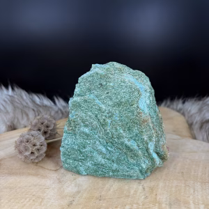Fuchsiet Cut-Base van 11 cm hoog met een sprankelende groene glans, Detail van de mica schittering in een Fuchsiet van 603 gram, Zijaanzicht van de 4 cm diepe Fuchsiet op een vlakke voet, Groene Fuchsiet Cut-Base op een houten plank in een lichte kamer.