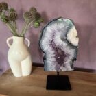 Amethist portaal op standaard, Paarse amethist edelsteen helder en glanzend, Amethist steen met diepe paarse kleur, Amethist kristal voor rust en bescherming, Close-up van amethist met natuurlijke structuur, Amethist steen die intuïtie en balans bevordert, Prachtige paarse amethist voor spiritueel gebruik