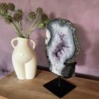 Amethist portaal op standaard, Paarse amethist edelsteen helder en glanzend, Amethist steen met diepe paarse kleur, Amethist kristal voor rust en bescherming, Close-up van amethist met natuurlijke structuur, Amethist steen die intuïtie en balans bevordert, Prachtige paarse amethist voor spiritueel gebruik
