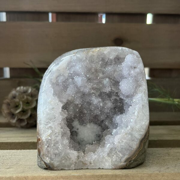 Amethist rus cut base, lichte amethist ruw cut-base op houten oppervlak, ruwe amethist steen met geslepen basis in zonlicht, spirituele amethist decoratie in meditatieruimte, close-up van lichte amethist kristalstructuur, amethist cut-base naast kaarsen en seleniet