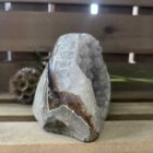 lichte amethist ruw cut-base op houten oppervlak, ruwe amethist steen met geslepen basis in zonlicht, spirituele amethist decoratie in meditatieruimte, close-up van lichte amethist kristalstructuur, amethist cut-base naast kaarsen en seleniet