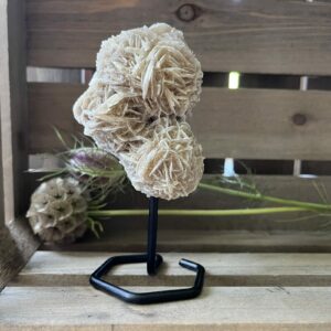 woestijnroos klein op standaard in interieur, spirituele werking woestijnroos decoratie, natuurlijke woestijnroos edelsteen op standaard, woestijnroos met rozetvorm op sokkel, bijzondere kristalsteen woestijnroos op display