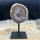 Glanzende Agaat geode op metalen standaard met kristalvorming, Close-up van sprankelende binnenzijde van de Agaat geode, Zijaanzicht van unieke Agaat geode met natuurlijke structuur, Agaat geode op houten tafel klaar voor meditatie of ritueel, Uniek Agaat geode exemplaar van 365 gram in natuurlijk licht