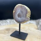 Glanzende Agaat geode op metalen standaard met kristalvorming, Close-up van sprankelende binnenzijde van de Agaat geode, Zijaanzicht van unieke Agaat geode met natuurlijke structuur, Agaat geode op houten tafel klaar voor meditatie of ritueel, Uniek Agaat geode exemplaar van 365 gram in natuurlijk licht