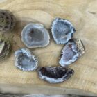 Smalle Agaat Geode Flat met glinsterende kristallen van dichtbij, Agaat geode op een altaar met salie en bergkristal, Detail van kristalvorming in een kleine Agaat Geode, Intuïtief gekozen Agaat Geode Flat op houten ondergrond, Hand met een Agaat Geode Flat tijdens meditatie