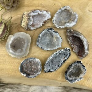 Smalle Agaat Geode Flat met glinsterende kristallen van dichtbij, Agaat geode op een altaar met salie en bergkristal, Detail van kristalvorming in een kleine Agaat Geode, Intuïtief gekozen Agaat Geode Flat op houten ondergrond, Hand met een Agaat Geode Flat tijdens meditatie