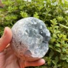 Celestien bol van 1,485 kg met blauwe kristallen close-up, Hemelsblauwe Celestien bol op witte achtergrond, Spirituele edelsteen Celestien op standaard weergegeven, Gedetailleerde structuur van Celestien kristallen in bolvorm, Celestien bol als altaarsteen met zachte glan