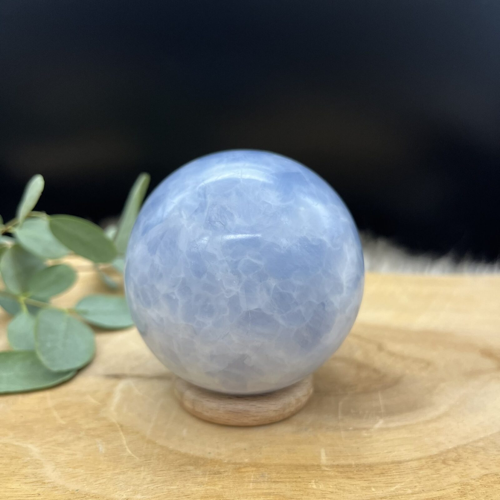 Blauwe calciet bol met gemêleerd patroon van wit en lichtblauw, Glanzende calciet bol van 462 gram met natuurlijke kleurschakeringen, Sierbol van blauwe calciet met wolkachtig gemêleerd effect, Calciet kristalbol van 8 cm doorsnee met zachte blauwe tinten, Handgeslepen blauwe calciet bol met marmerachtig patroon, Decoratieve edelsteen bol van calciet met rustgevende blauwe nuances