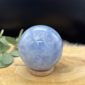 Blauwe calciet bol met gemêleerd patroon van wit en lichtblauw, Glanzende calciet bol van 462 gram met natuurlijke kleurschakeringen, Sierbol van blauwe calciet met wolkachtig gemêleerd effect, Calciet kristalbol van 8 cm doorsnee met zachte blauwe tinten, Handgeslepen blauwe calciet bol met marmerachtig patroon, Decoratieve edelsteen bol van calciet met rustgevende blauwe nuances