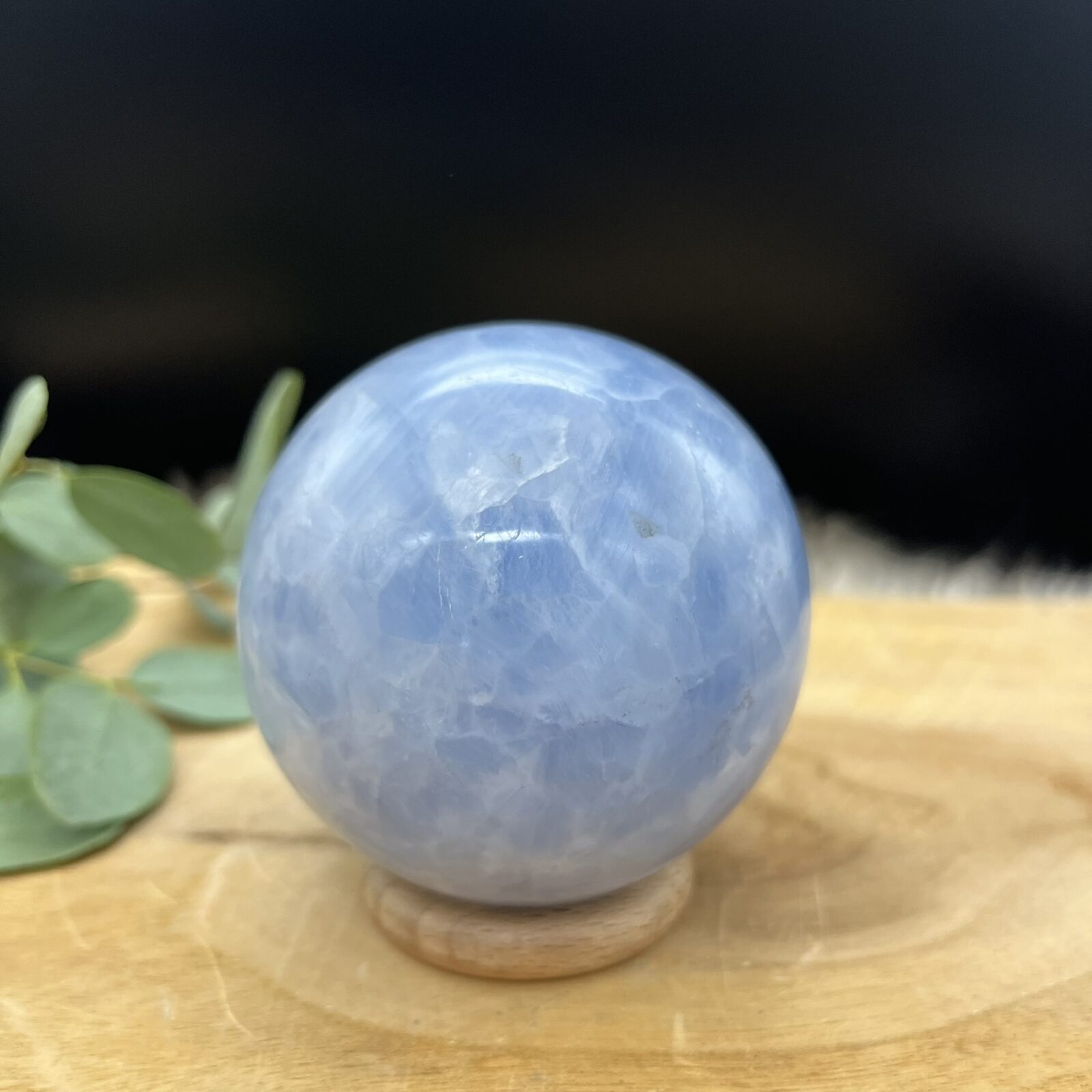 Blauwe calciet bol met gemêleerd patroon van wit en lichtblauw, Glanzende calciet bol van 462 gram met natuurlijke kleurschakeringen, Sierbol van blauwe calciet met wolkachtig gemêleerd effect, Calciet kristalbol van 8 cm doorsnee met zachte blauwe tinten, Handgeslepen blauwe calciet bol met marmerachtig patroon, Decoratieve edelsteen bol van calciet met rustgevende blauwe nuances