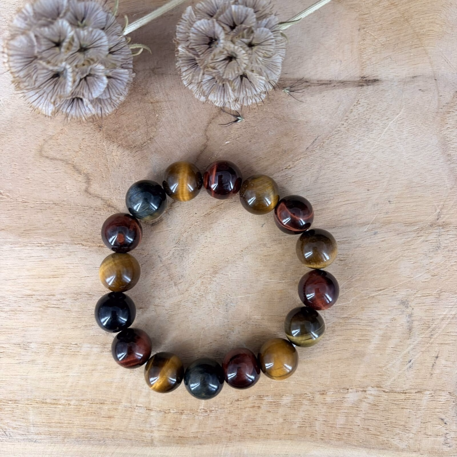 Drie kleuren tijgeroog armband, Tijgeroog tricolor armband, Tijgeroog tricolor armband met grote kralen van 12 mm in goud, blauw en rood, stoere edelsteen armband met 12 mm tijgeroog kralen voor bescherming en moed, close-up van een robuuste tricolor tijgeroog armband met prachtige zijdeglans, handgemaakte armband van 45 gram tijgeroog mix voor meer zelfvertrouwen en daadkracht, spirituele tijgeroog armband met grove kralen die helpt bij balans en focus, detailfoto van een tijgeroog tricolor 12 mm armband met unieke natuurlijke kleurpatronen.