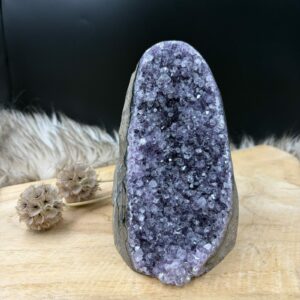 ruwe amethist cut base 1358 gram dieppaars kristal natuursteentje, detail paarse amethist kristallen ruw natuurproduct, staand amethist cluster vlakke onderkant interieur, amethist cut base op nachtkastje voor rust en balans, zijaanzicht amethist kristal met natuurlijke grijze rand, grote paarse amethist punt op voetstuk voor meditatie