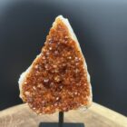 citrien op houten standaard met fijne kristallen, natuurlijke citrien gepresenteerd op warme houten voet, fonkelende citrien met subtiele glans op standaard, citrien edelsteen stijlvol tentoongesteld op houten basis, citrien cluster op houten voet die warmte uitstraalt, zonnige citrien op standaard als spirituele decoratie