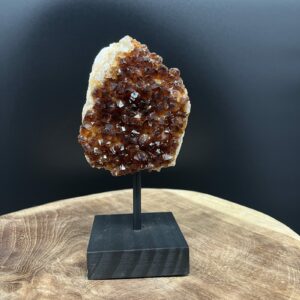 citrien geode op standaard met zwarte houten voet, citrien geode stijlvol tentoongesteld op donkere houten basis, glanzende citrien kristallen in open geode op standaard, natuurlijke citrien geode rechtop gepresenteerd als decorstuk, citrien edelsteen geode op stevige zwarte voet voor spirituele uitstraling, citrien cluster op houten standaard die warmte en licht verspreidt