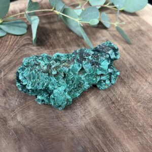 ruwe malachiet 135 gram met fluweelgroene patronen, natuurlijke malachiet ruw op display, fluweel malachiet steen met diepe groene lagen, malachiet ruw gepresenteerd als spirituele decoratie, glanzende ruwe malachiet met natuurlijke banden, malachiet ruw 135 g als edelsteen voor transformatie en balans
