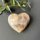 Roze amethist hart van 297 gram, glanzend gepolijst en liggend op een houten standaard, straalt zachte energie en liefde uit, zachtroze amethist hart van 9 cm breed in een lichte interieursetting, symbool van rust en harmonie in huis, glanzend roze amethist hart op bergkristal en hematiet uit het op- en ontlaad setje, klaar om opnieuw energie te laden, edelsteen hart van roze amethist op tafel bij kaarslicht, verspreidt een kalme en liefdevolle sfeer tijdens meditatie, natuurlijke roze amethist met zichtbare kristallen, hartvormig geslepen en perfect als decoratief spiritueel accent, roze amethist hart van 297 gram gefotografeerd naast andere edelsteen harten, ideaal cadeau voor liefde en innerlijke rust