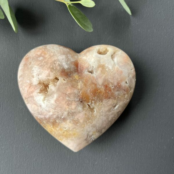 Roze amethist hart van 297 gram, glanzend gepolijst en liggend op een houten standaard, straalt zachte energie en liefde uit, zachtroze amethist hart van 9 cm breed in een lichte interieursetting, symbool van rust en harmonie in huis, glanzend roze amethist hart op bergkristal en hematiet uit het op- en ontlaad setje, klaar om opnieuw energie te laden, edelsteen hart van roze amethist op tafel bij kaarslicht, verspreidt een kalme en liefdevolle sfeer tijdens meditatie, natuurlijke roze amethist met zichtbare kristallen, hartvormig geslepen en perfect als decoratief spiritueel accent, roze amethist hart van 297 gram gefotografeerd naast andere edelsteen harten, ideaal cadeau voor liefde en innerlijke rust