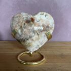 Roze amethist hart van 297 gram, glanzend gepolijst en liggend op een houten standaard, straalt zachte energie en liefde uit, zachtroze amethist hart van 9 cm breed in een lichte interieursetting, symbool van rust en harmonie in huis, glanzend roze amethist hart op bergkristal en hematiet uit het op- en ontlaad setje, klaar om opnieuw energie te laden, edelsteen hart van roze amethist op tafel bij kaarslicht, verspreidt een kalme en liefdevolle sfeer tijdens meditatie, natuurlijke roze amethist met zichtbare kristallen, hartvormig geslepen en perfect als decoratief spiritueel accent, roze amethist hart van 297 gram gefotografeerd naast andere edelsteen harten, ideaal cadeau voor liefde en innerlijke rust