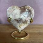 Roze amethist hart van 297 gram, glanzend gepolijst en liggend op een houten standaard, straalt zachte energie en liefde uit, zachtroze amethist hart van 9 cm breed in een lichte interieursetting, symbool van rust en harmonie in huis, glanzend roze amethist hart op bergkristal en hematiet uit het op- en ontlaad setje, klaar om opnieuw energie te laden, edelsteen hart van roze amethist op tafel bij kaarslicht, verspreidt een kalme en liefdevolle sfeer tijdens meditatie, natuurlijke roze amethist met zichtbare kristallen, hartvormig geslepen en perfect als decoratief spiritueel accent, roze amethist hart van 297 gram gefotografeerd naast andere edelsteen harten, ideaal cadeau voor liefde en innerlijke rust