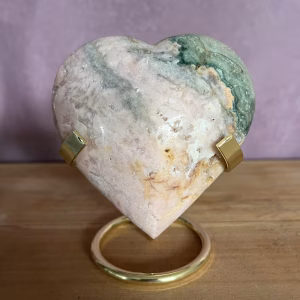 Pink amethyst heart van 314 gram met kristallen, roze amethist hart 9,5 cm op houten standaard, pink amethyst heart op bergkristal en hematiet uit het op- en ontlaad setje, close-up van kristallen in pink amethyst heart met zachte glans, pink amethyst heart in meditatiehoek bij kaarslicht, roze amethist hart als liefdevol cadeau op houten tafel.