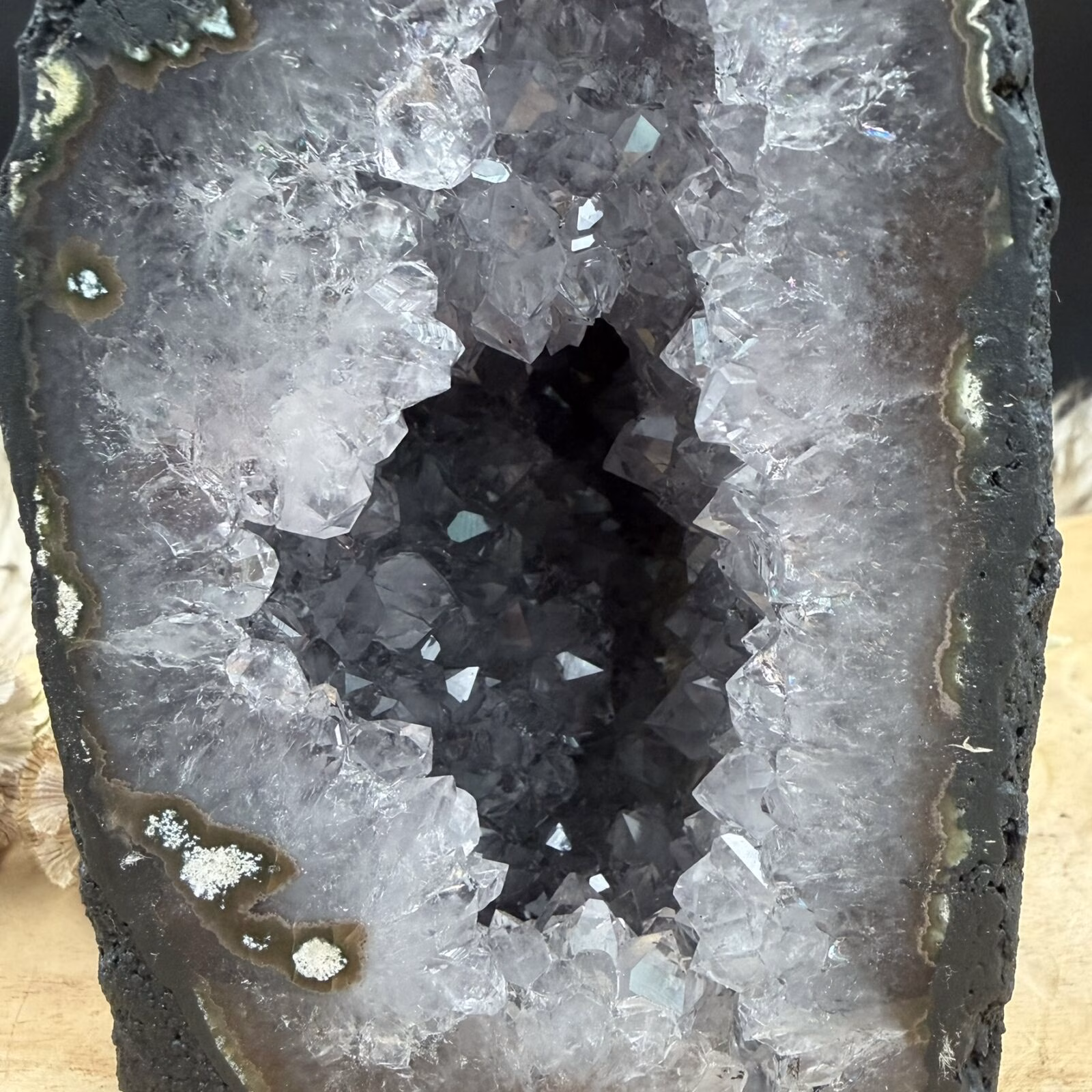 Close-up van grijze kristallen in een amethist geode kathedraal met natuurlijke glinstering en neutrale tinten.