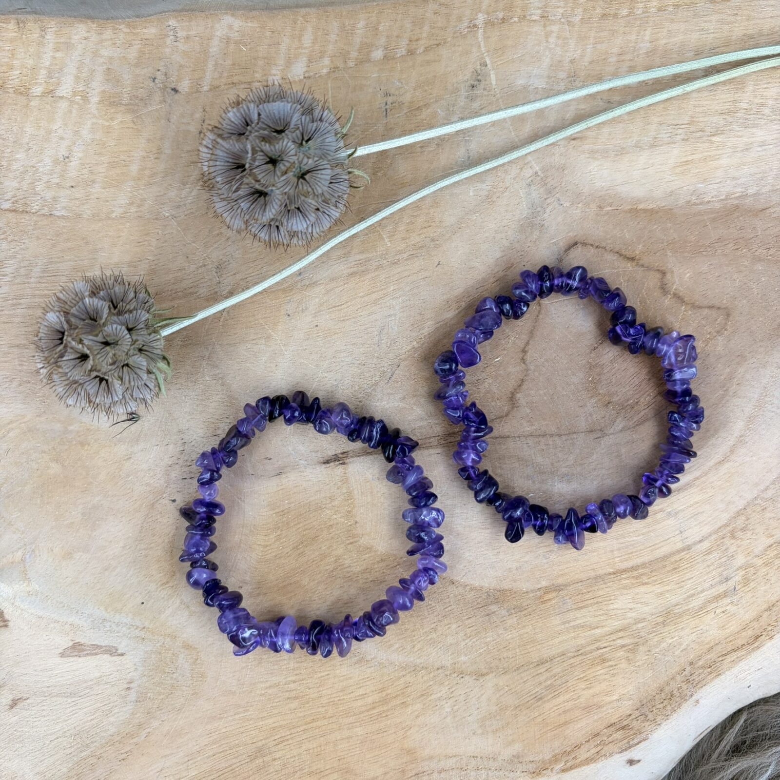 Amethist splitarmband, Amethist splitarmband van hoge A-kwaliteit met dieppaarse edelstenen, elastische armband met heldere paarse amethist splitstenen voor rust en balans, close-up van een glanzende paarse edelsteen armband van natuurlijke amethist, handgemaakte armband met amethist kristallen van de beste kwaliteit, spirituele paarse amethist armband voor meditatie en innerlijke rust, detail van een amethist splitarmband met intens paarse kleuren en natuurlijke glans.