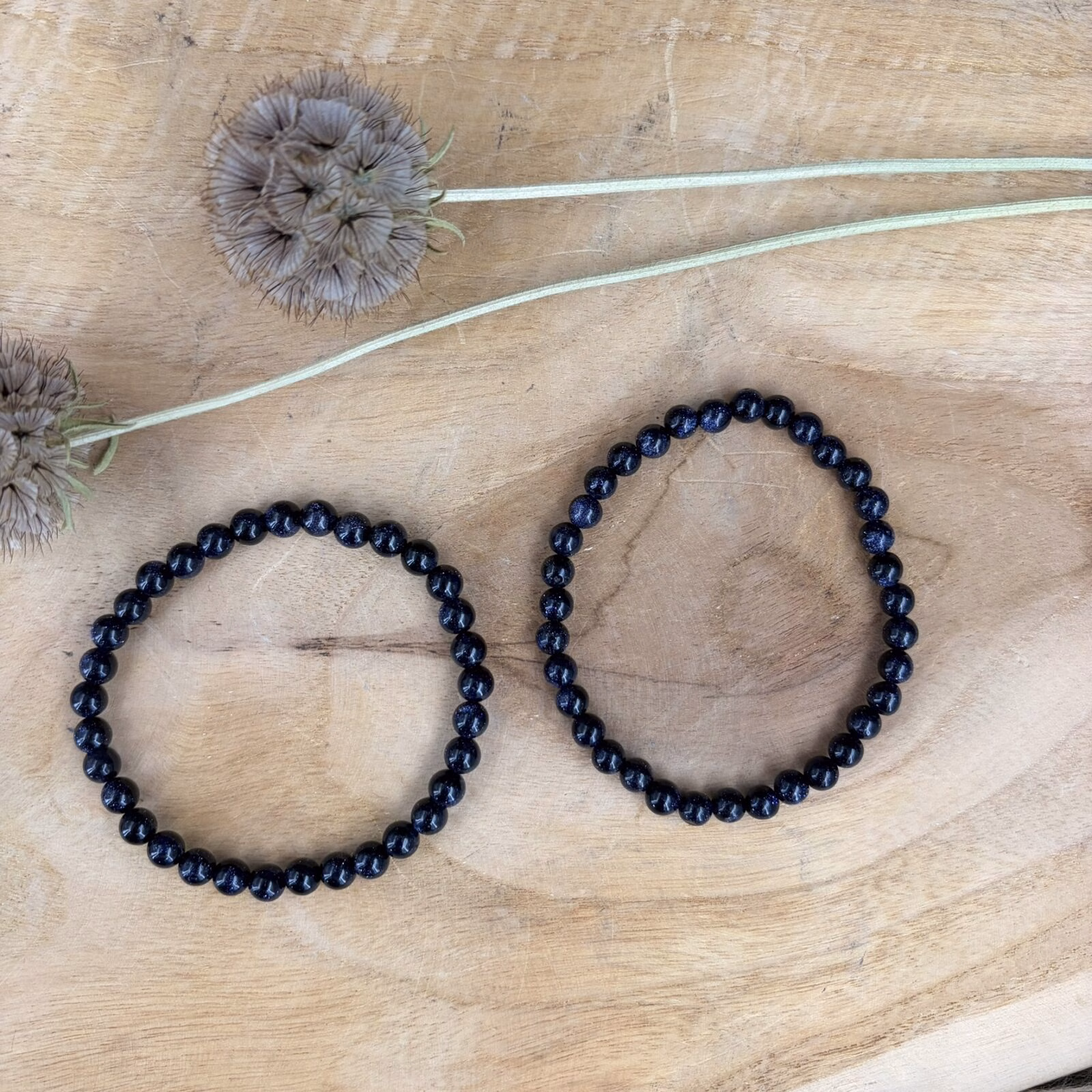 Blauwe goudsteen armband 6 mm, Blauwe goudsteen armband met fonkelende kralen van 6 mm, elastische armband met schitterende donkerblauwe goudsteen voor hoop en licht, close-up van een 6 mm kralen armband met glinsterende blauwe details, handgemaakte armband van blauwe goudsteen met een magische nachtblauwe uitstraling, subtiele blauwe goudsteen armband met ronde kralen van 6 millimeter, detailfoto van de fijne glitters in een blauwe goudsteen edelsteen armband.