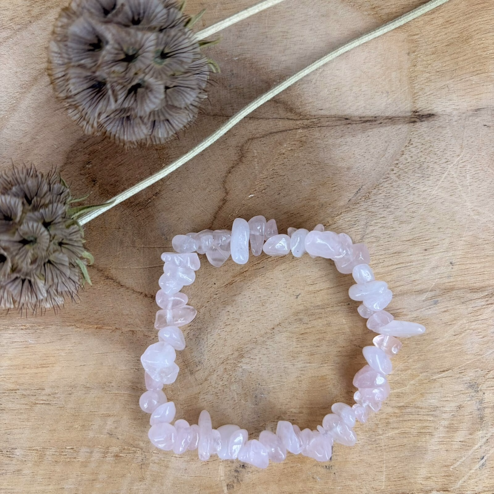 Rozekwarts splitarmband, Roze splitarmband gemaakt van kleine stukjes gepolijste rozenkwarts edelsteen, close-up van een elastische armband met zachtroze rozenkwarts splitstenen, handgemaakte edelsteen armband met natuurlijke roze kristallen op een witte achtergrond, vrouw die een subtiele rozenkwarts splitarmband om haar pols draagt, detailfoto van de unieke vormen van roze kwarts stenen in een armband, set van meerdere rozenkwarts armbandjes met kleine glanzende mineraalstenen.
