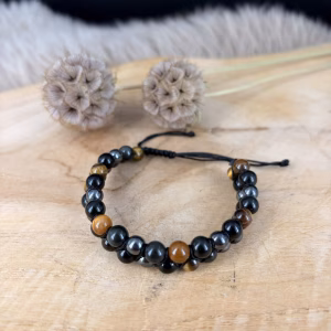 Hematiet Obsidiaan en Tijgeroog armband dubbel, Hematiet Obsidiaan en Tijgeroog armband, Dubbele edelsteen armband met twee rijen van 6 mm kralen hematiet, obsidiaan en tijgeroog, verstelbare dubbele armband met touw treksluiting voor optimale aarding en bescherming, close-up van een handgemaakte armband met zwarte obsidiaan en tijgeroog voor focus, stoere dubbele heren en dames armband van 17 gram met glanzende hematiet kralen, spirituele armband met dubbele rij 6 mm kralen die negatieve energie absorbeert, detailfoto van de verstelbare treksluiting van een hematiet en tijgeroog trio armband.