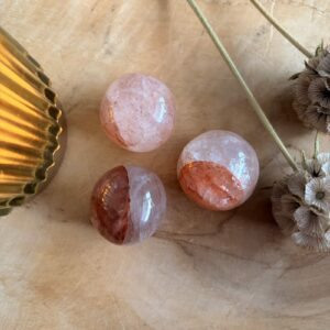 Hematoïde kwarts bolletje roodbruin patroon, Hematoïde kwarts bolletje op witte achtergrond, Hematoïde kwarts bolletje van 2,5 cm, Hematoïde kwarts bolletje met rode en gouden insluitingen, Hematoïde kwarts bolletje uit Madagaskar, Hematoïde kwarts bolletje op houten tafel, Hematoïde kwarts bolletje edelsteen rond