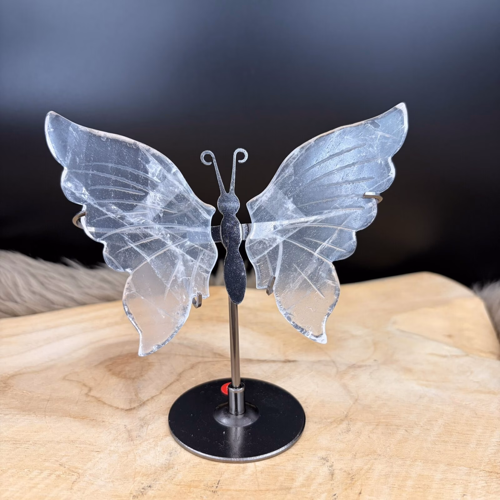 Decoratieve Bergkristal vlinder op standaard met een zilverkleurig lijfje als symbool voor vrijheid, transparant kwarts op metalen voet voor focus tijdens werk, uniek natuurproduct met schitterende vleugels.