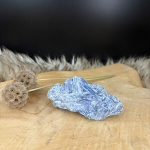 Kyaniet Ruw met een glanzende gelaagde structuur van 9 cm lang, Detail van de diepblauwe banen in een ruwe Kyaniet steen van 140 gram, Kyaniet mineraal met een trikliene kristalvorm op een lichte achtergrond, Blauwe Kyaniet Ruw voor rust en heldere communicatie in huis.