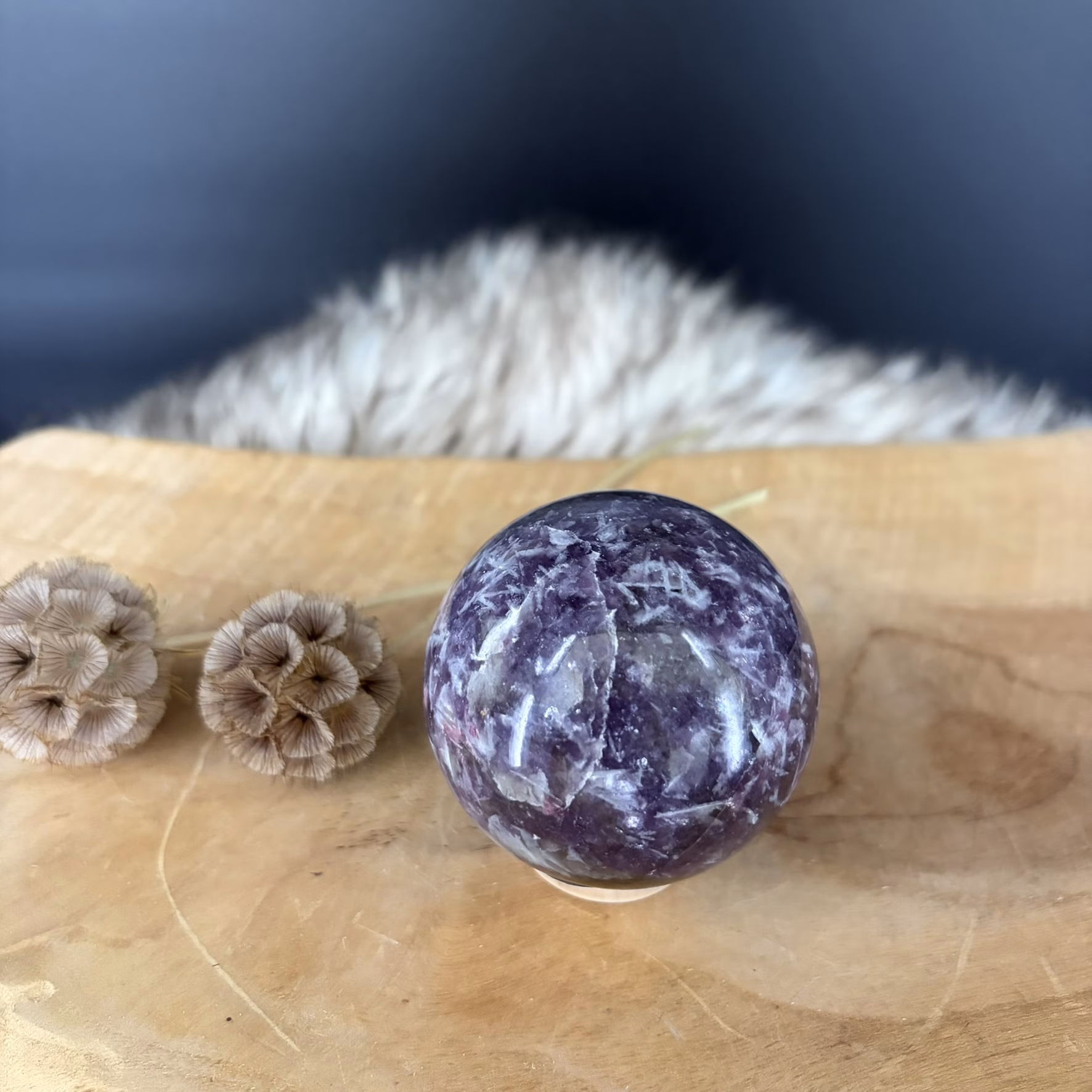 lepidoliet bol op houten plank met gedroogde bloemen