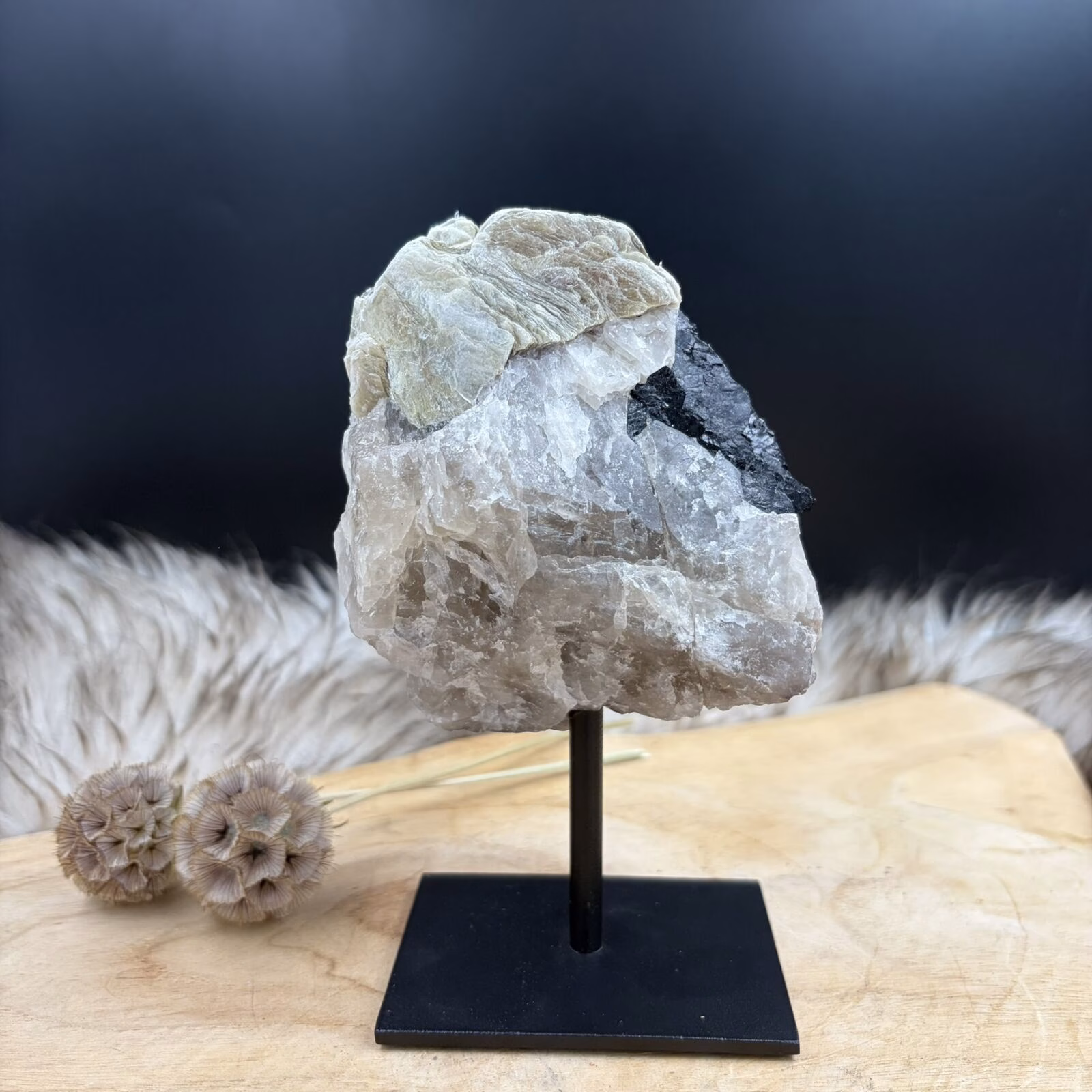 ruwe mica met zwarte toermalijn op zwarte standaard
